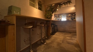 Una cocina con barra, incluyendo dos taburetes, una encimera y una planta en maceta.