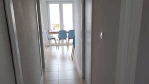 A hallway with a dining area at the end, featuring a table and chairs. - BEAUTIFUL APARTMENT VACATION RENTAL PLAYA SAN JUAN ALICANTE (san juan alicante)