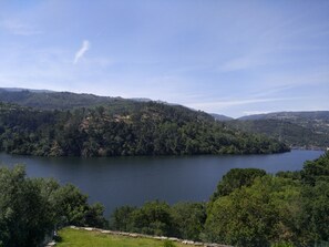 A lake surrounded by hills with a clear sky. - Douro Valley With Family (Paços de Gaiolo)