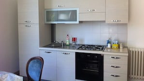 Una cocina compacta con estufa a gas, microondas y lavavajillas.
