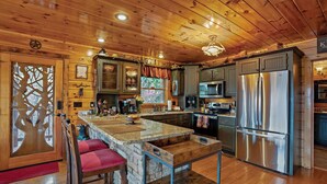 Een houten cabin met een keuken, een stenen bar en een zithoek.