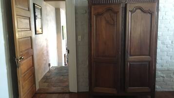 A hallway with wooden doors and a large wooden cabinet.