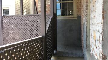 A staircase with a metal railing, brick walls, and a window.