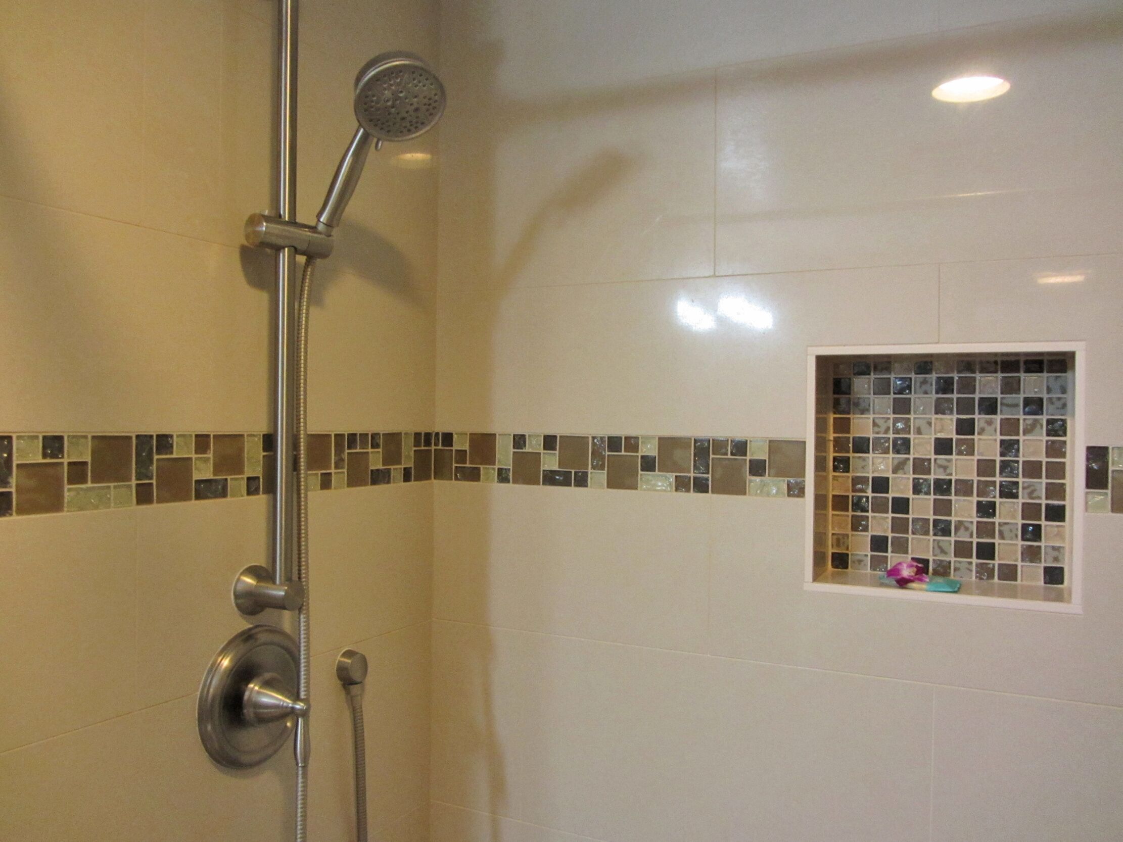 Ducha con cabezal de ducha de mano y mandos empotrados.