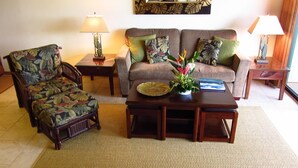 A living room with a sofa, armchair, coffee table, and two side tables with lamps. -  Now with AC!    Ocean View  2 bd 2 Bath, 1 story condo at the Makahuena. (Poipu Beach)