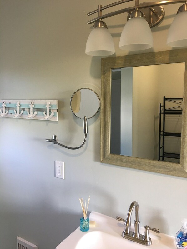 Un baño con lavabo, espejo y barra para toallas.