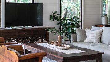 Una sala de estar con una mesa de centro de madera, un sofá y un televisor.