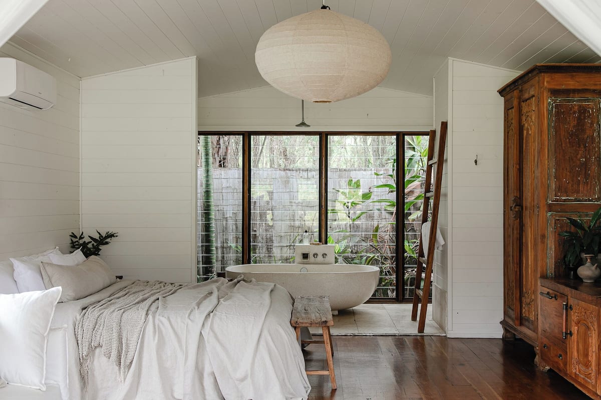 Une chambre à coucher avec un grand lit, une armoire en bois et une baignoire.