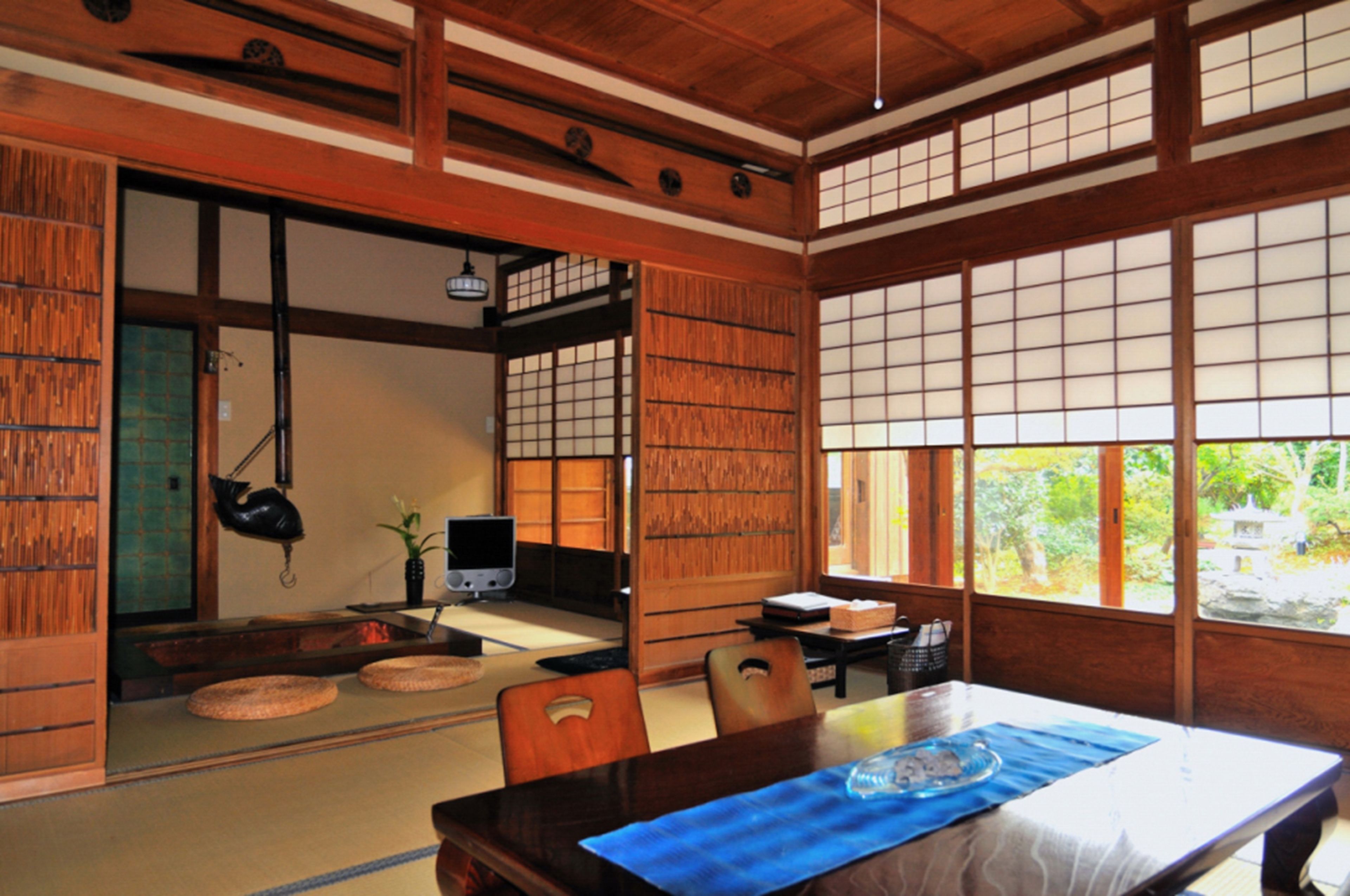 Una habitación japonesa tradicional con suelo de tatami, una mesa baja y puertas correderas.