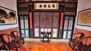 A traditional Chinese room with a tiled floor, wooden furniture, and decorative panels. - Feng Mao Lin Zh (Jincheng)