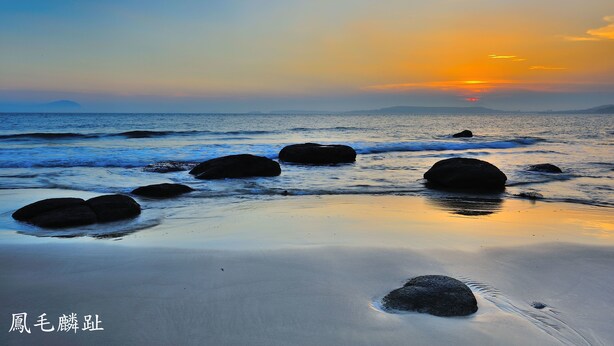 A beach with rocks and calm water during sunset. - Feng Mao Lin Zh (Jincheng)