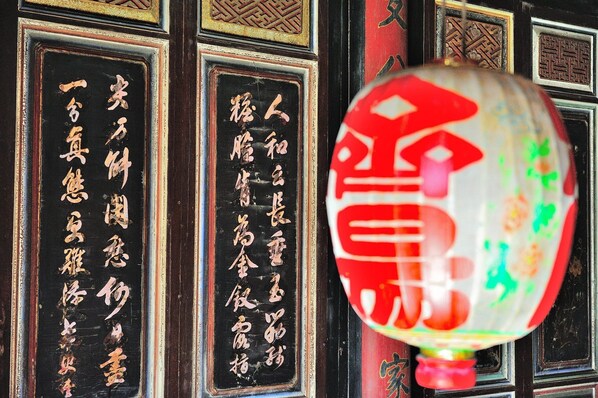 Una puerta tradicional china con caligrafía y un farol rojo.