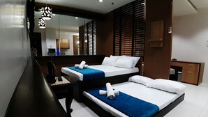 A hotel room with two beds, a desk, a mirror, and a wardrobe. - Luxury Loft in Cebu City (Cebu City)