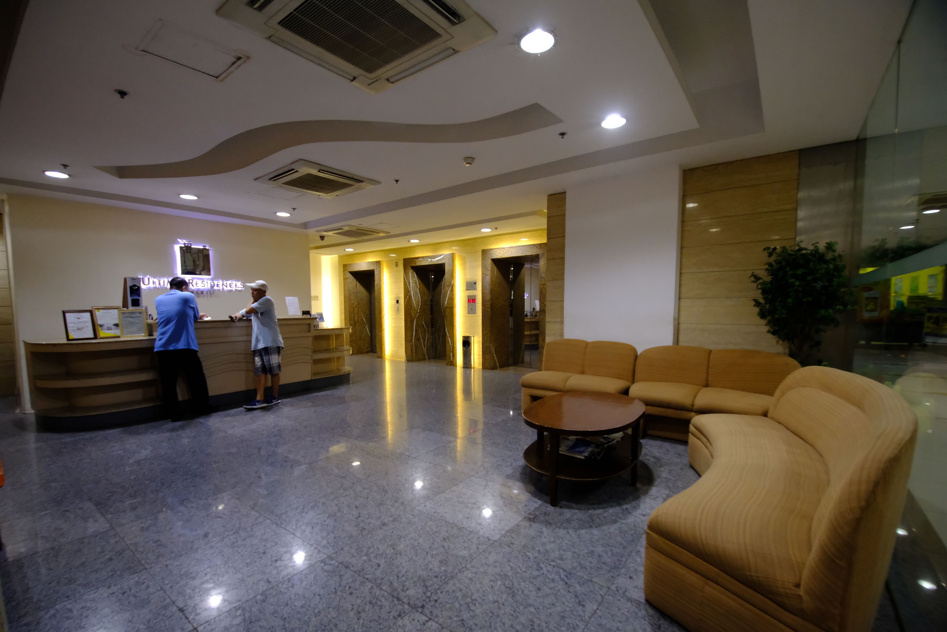 Un hall de hotel con una recepción, un sofá y una mesa de centro.