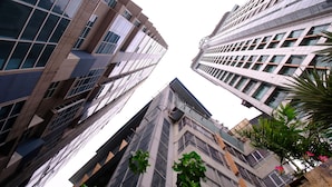 A view of tall, modern buildings with large windows and balconies, and some greenery in the foreground. - Luxury Loft in Cebu City (Cebu City)
