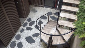 Una escalera de madera con barandilla de metal que sube a un nivel superior.