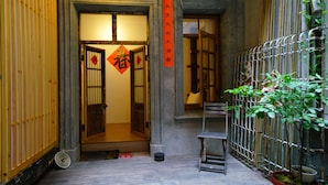 Un ingresso tradizionale giapponese con porte scorrevoli in legno, un piccolo tavolo e una pianta in vaso.