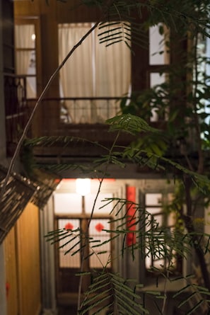 A staircase with a plant in the foreground, leading to a second-floor balcony with a railing.