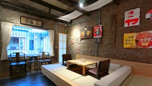 Un ristorante accogliente con pavimento in legno, un lungo tavolo da pranzo con sedie e una panca imbottita.