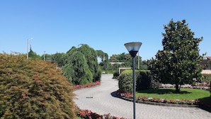 A paved pathway with flower beds and a lamppost. - Hotel Motel Luna (Segrate)