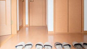 A hallway with wooden doors and a tiled floor. - Guesthouse ILOHA (Kyoto)
