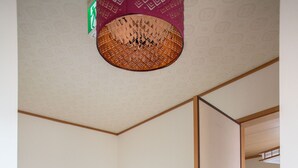 A room with a sliding door, a wooden floor, and a ceiling light fixture. - Guesthouse ILOHA (Kyoto)