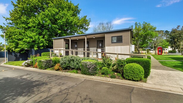 A modern single-story building with a covered porch and a small garden area. - Traralgon Holiday Village (Traralgon)