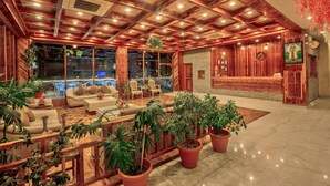 Un hall d’entrée spacieux avec un plafond en bois, des sièges confortables et des plantes en pot.