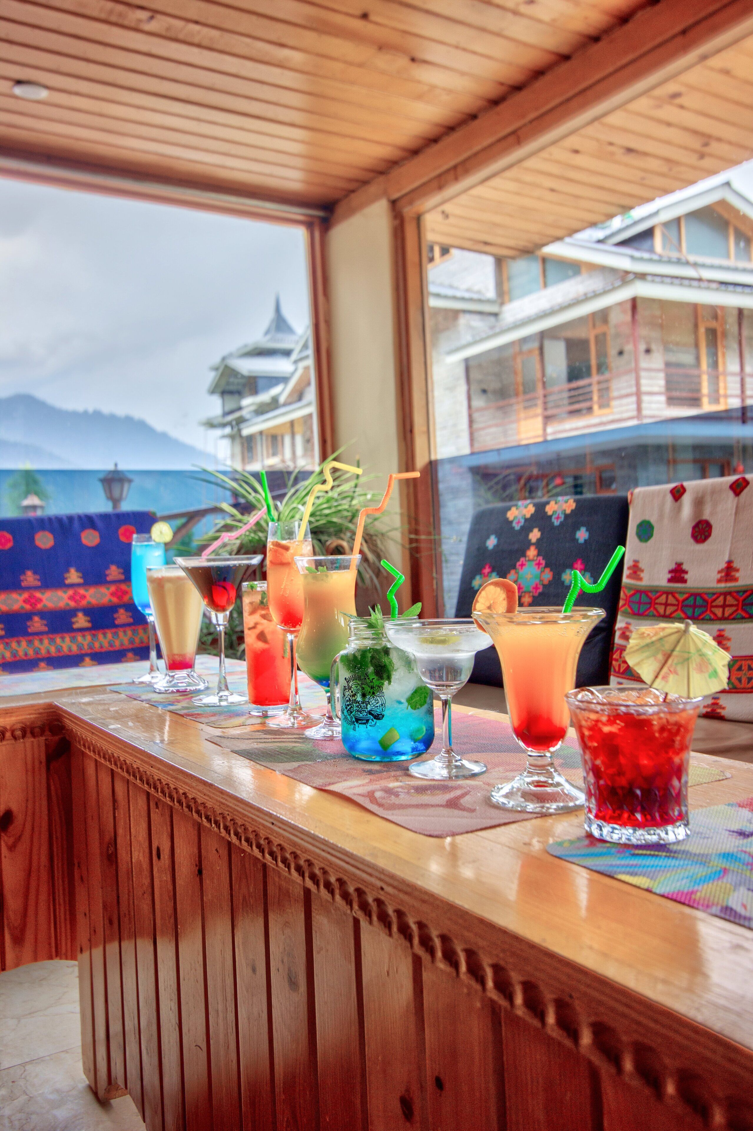 A bar area with various drinks and a view of traditional buildings through a window.