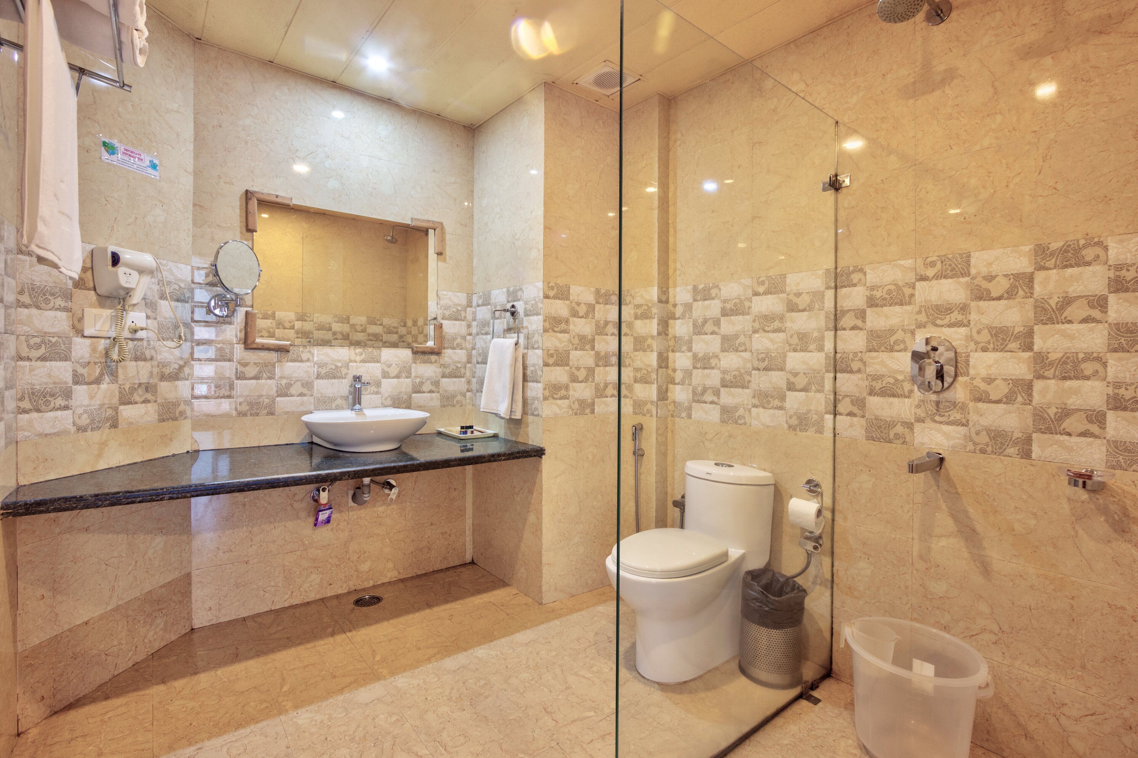 A modern bathroom with a glass-enclosed shower, a sink, and a toilet.