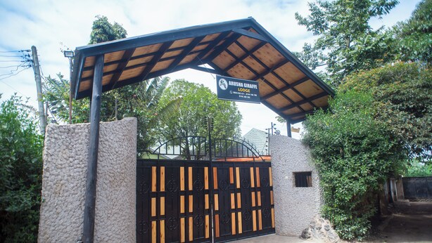 Ein verschlossenes Tor mit einem Schild für das Arusha Giraffe Lodge.