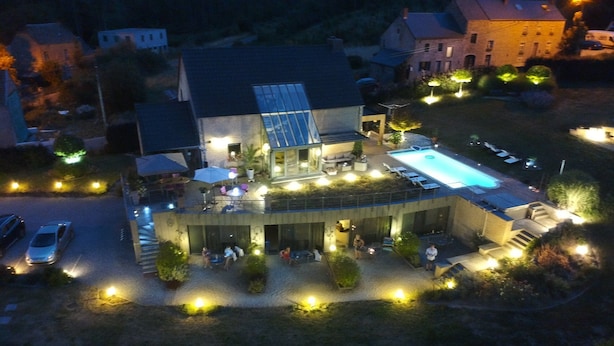 Un edificio moderno con piscina, zona de estar al aire libre y un patio bien iluminado.