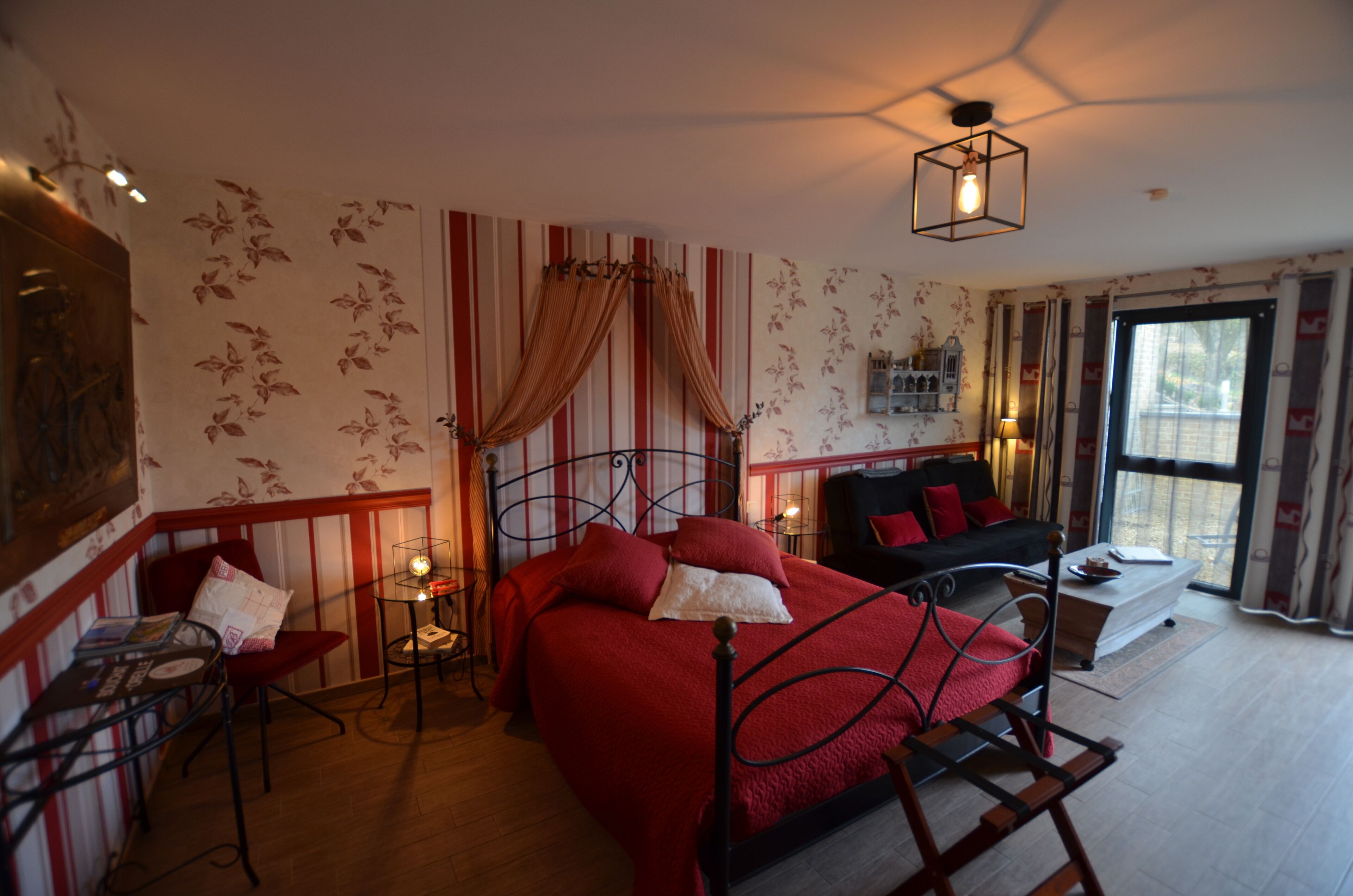 Una habitación con cama, una silla, una mesa y una ventana.