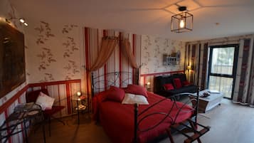 A room with a bed, a chair, a table, and a window.