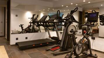 A gym with multiple cardio machines, a treadmill, and a stationary bike.
