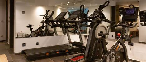 A gym with multiple cardio machines, a treadmill, and a stationary bike.