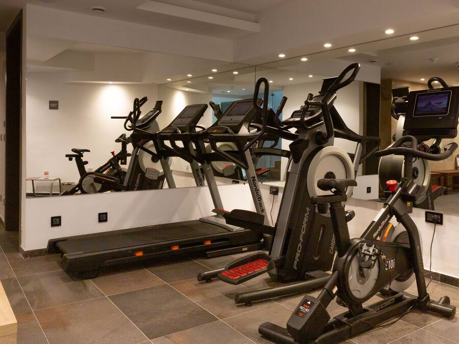 A gym with multiple cardio machines, a treadmill, and a stationary bike.