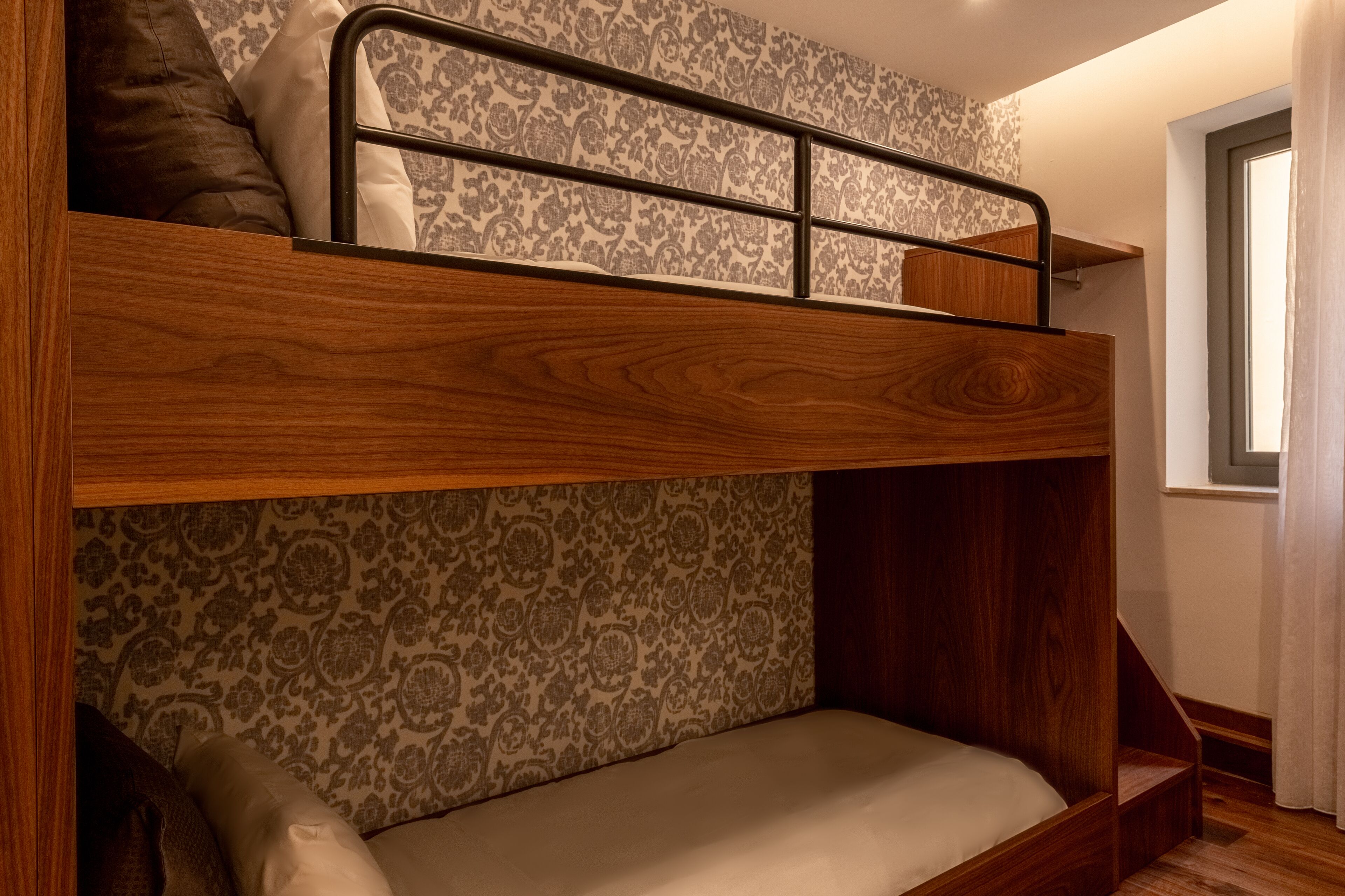 Ein Stockbett mit Holzrahmen und einem Wanddesign mit Muster.