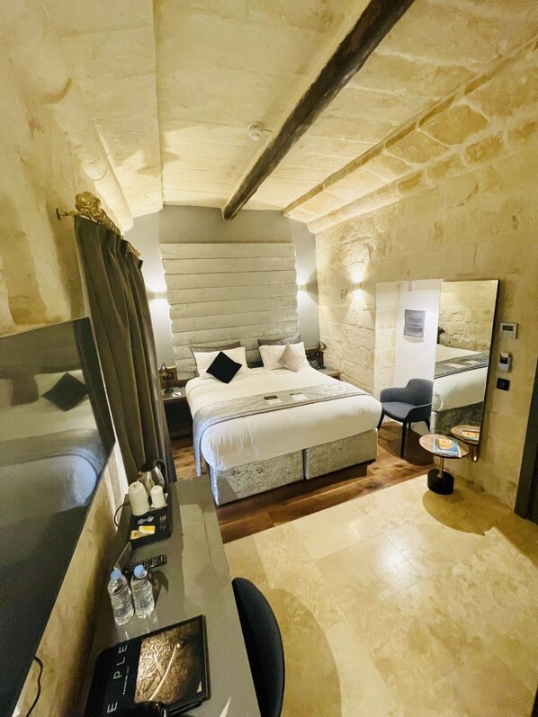 A bedroom with a bed, bedside table, and a mirror. - The Village Boutique & Spa (Naxxar)