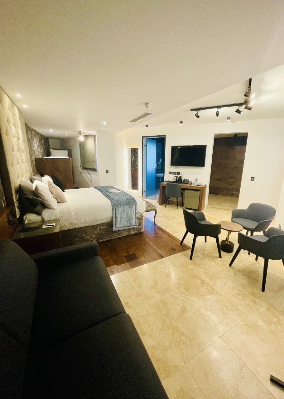 A modern bedroom with a bed, bedside table, and a desk area with a chair.