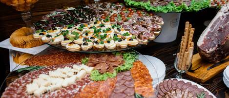 Diversos productos alimenticios, entre quesos, embutidos y aperitivos, dispuestos en bandejas.