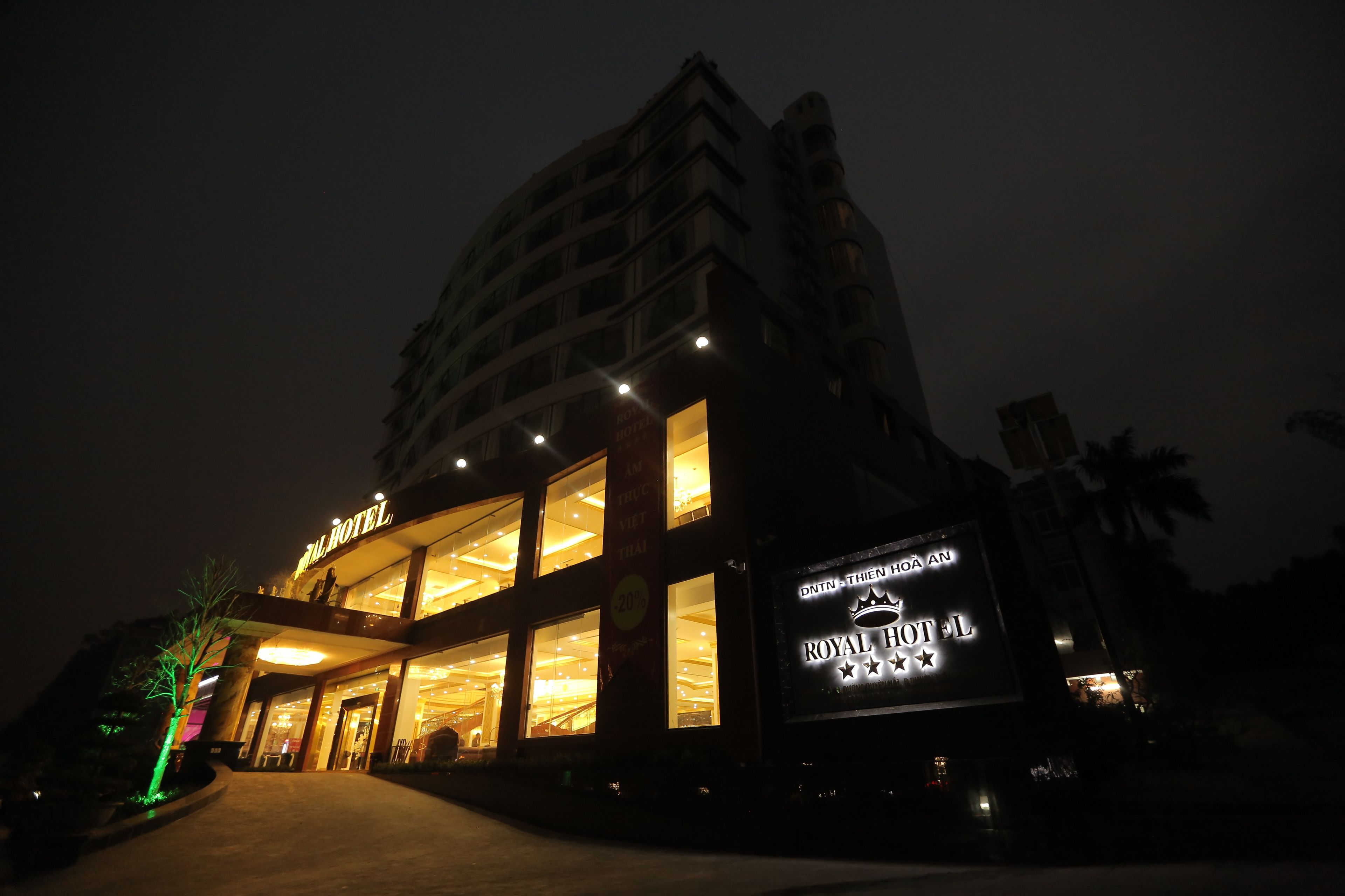 Un hotel con un letrero llamativo que dice "ROYAL HOTEL" y una entrada grande iluminada.
