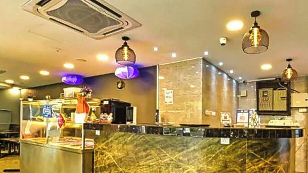 A hotel lobby with a marble reception desk, pendant lighting, and a wall-mounted television. - Hotel Sunjoy9 Bandar Sunway (Petaling Jaya)