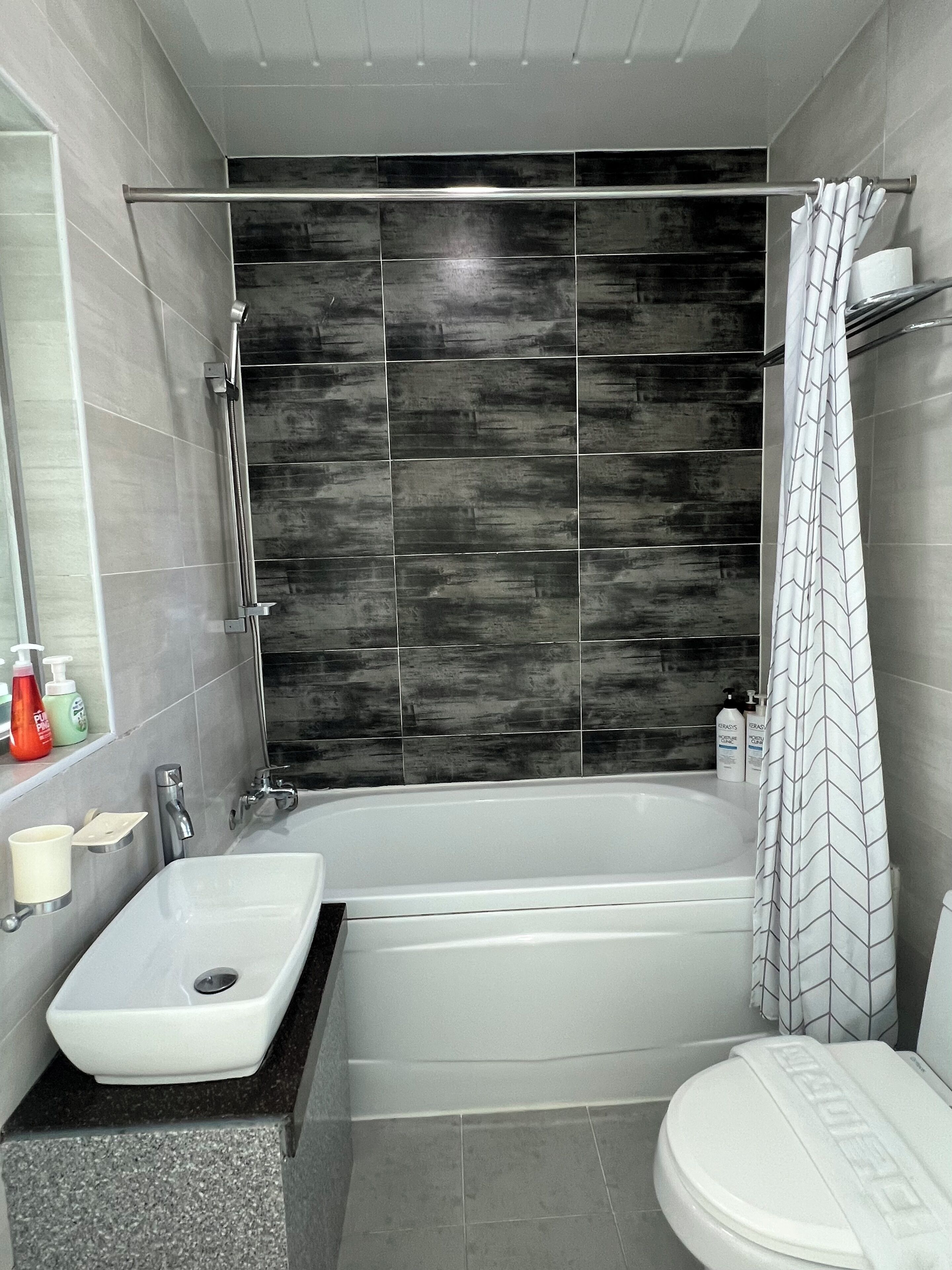 A modern bathroom with a bathtub, a sink, and a toilet.