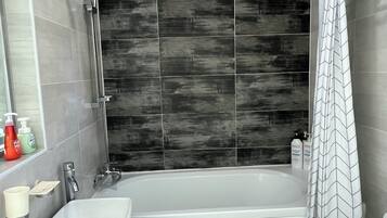 A modern bathroom with a bathtub, a sink, and a toilet.