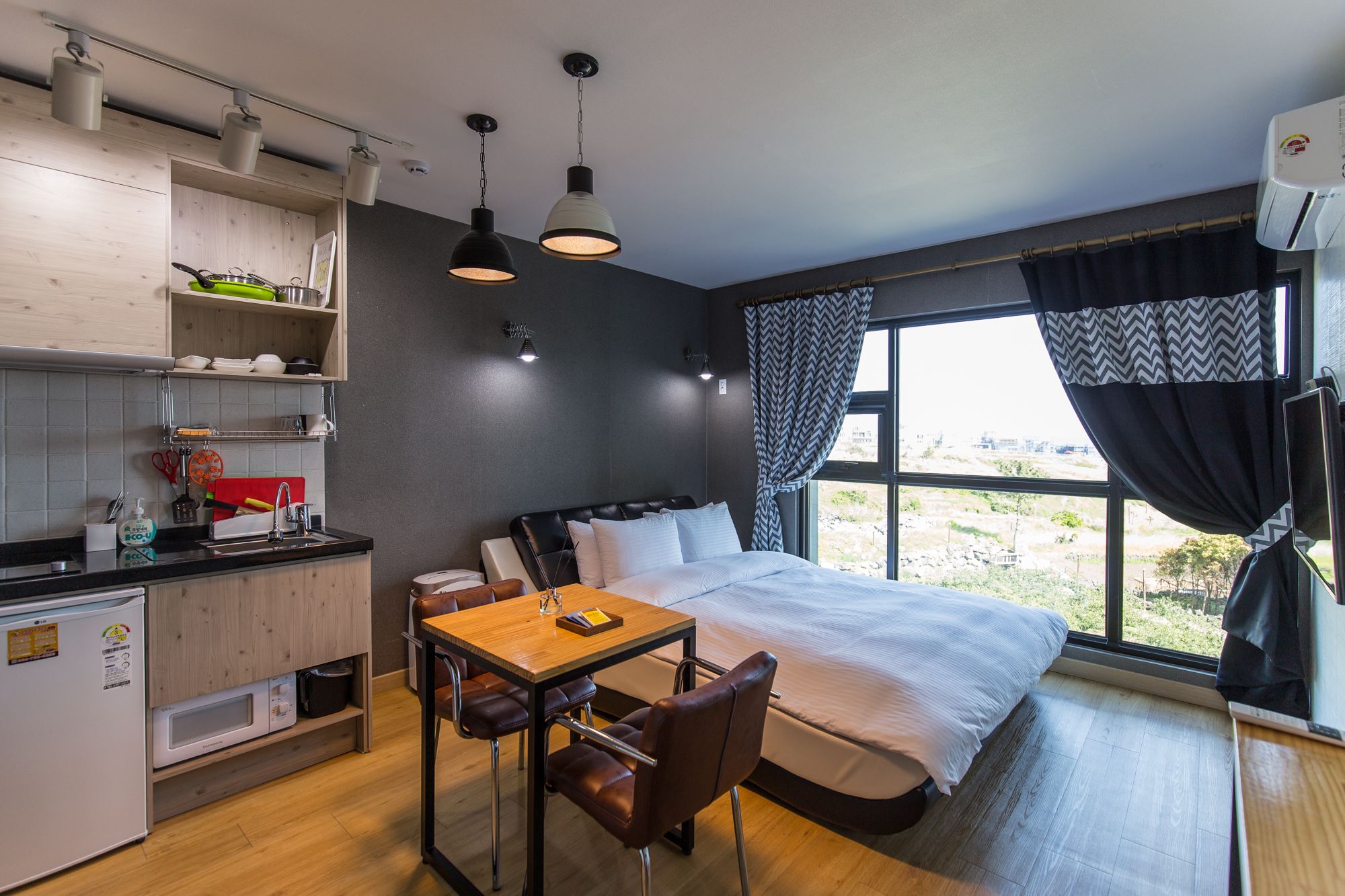Habitació d'hotel compacta amb cuineta, un llit amb vistes i zona de menjador.