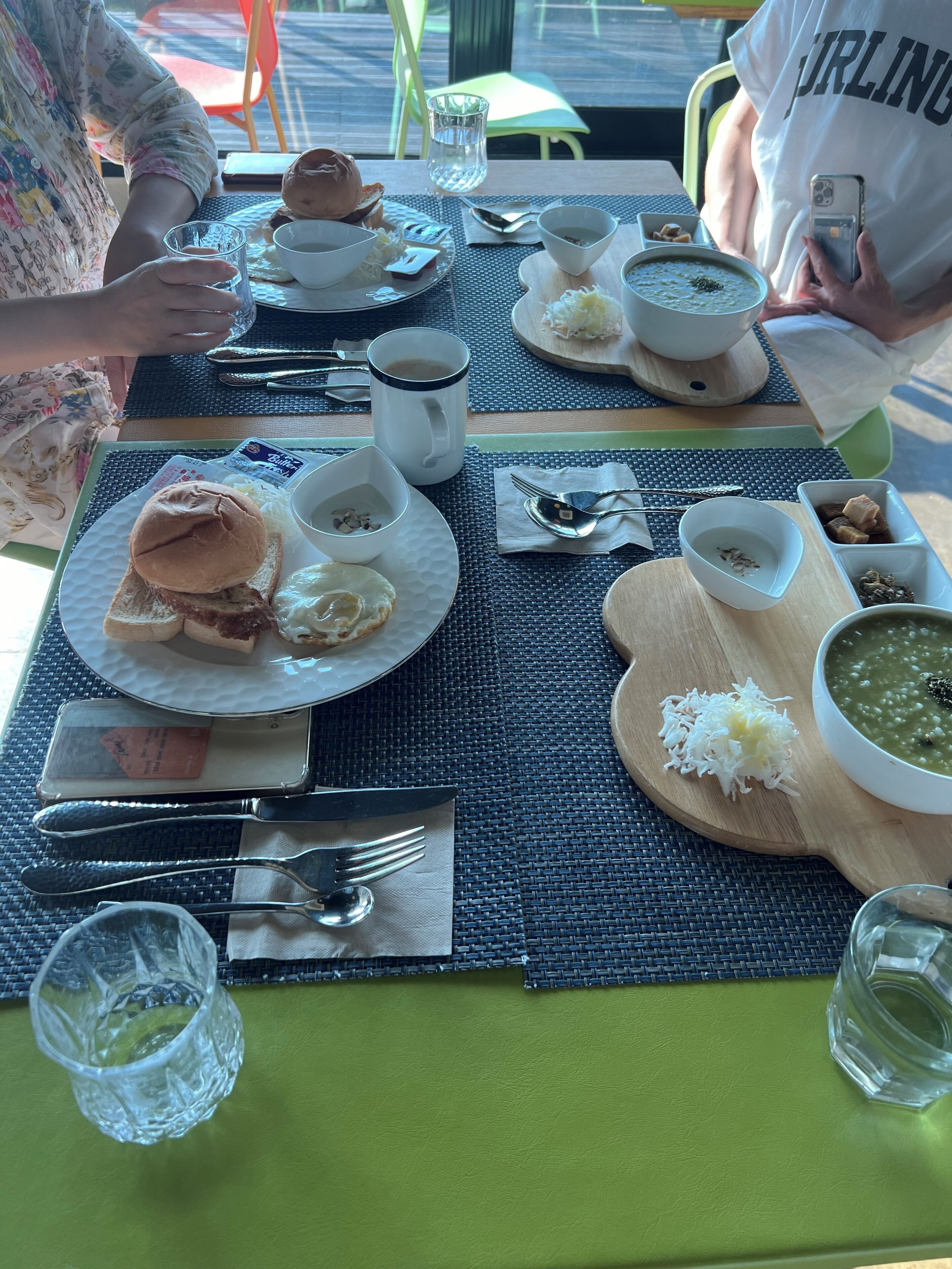 A dining table with various dishes, including a sandwich, soup, and rice.