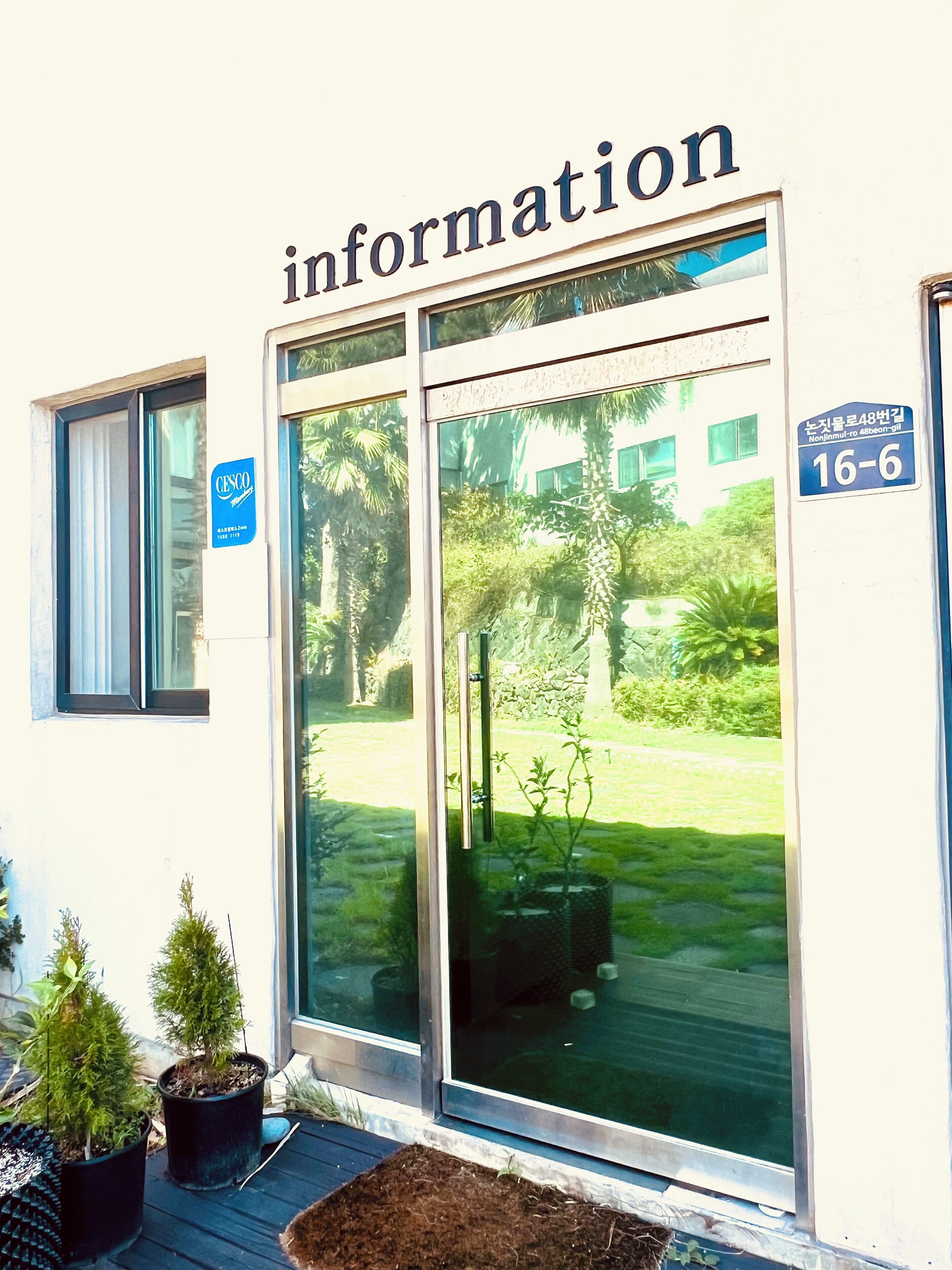 A building entrance with a sign reading "information" and a blue sign indicating room number 16-6.