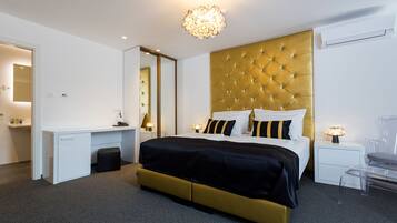 Une chambre d’hôtel moderne, dotée d’un grand lit, d’un bureau et d’une chaise.
