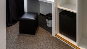 A hotel room with a white desk, a black telephone, a black ottoman, a white trash bin, and a white wardrobe with shelves. - B Gold Luxury Rooms (Split)
